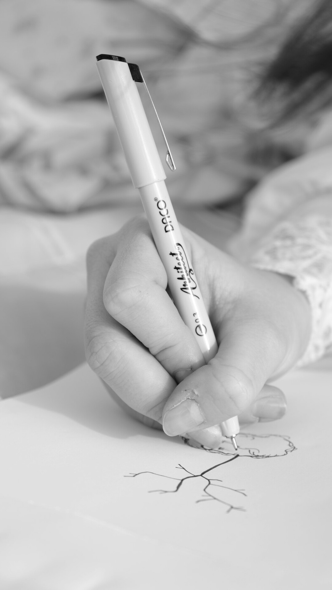 Close-up of hands writing observational notes with a pen on paper