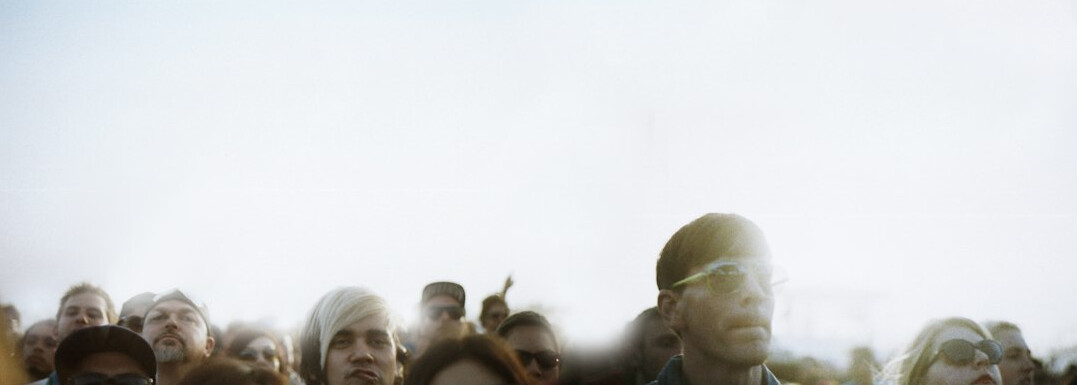 Anonymous crowd of people seen from a distance in soft light